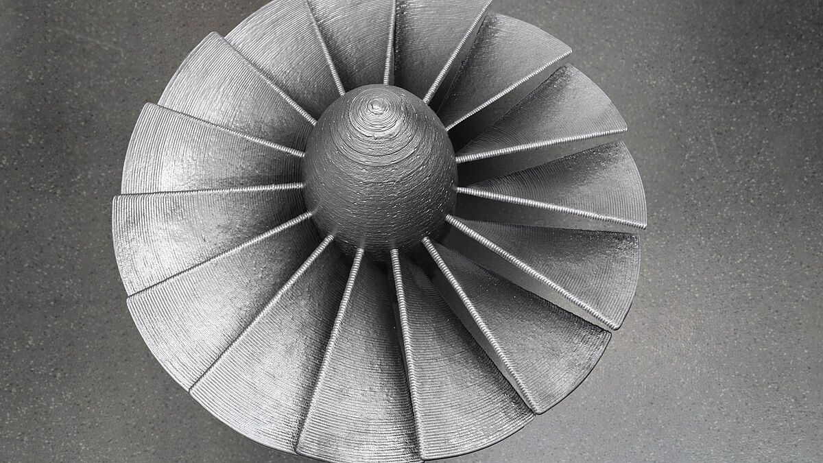 L’impression 3D permet d’économiser des ressources : cette hélice réalisée par fabrication additive (acier G3Si1) aurait dû être fraisée dans un bloc de dimensions 60 x 90 x 90 cm et d’environ 4 tonnes, tandis que la pièce achevée pèse à peine 100 kg.