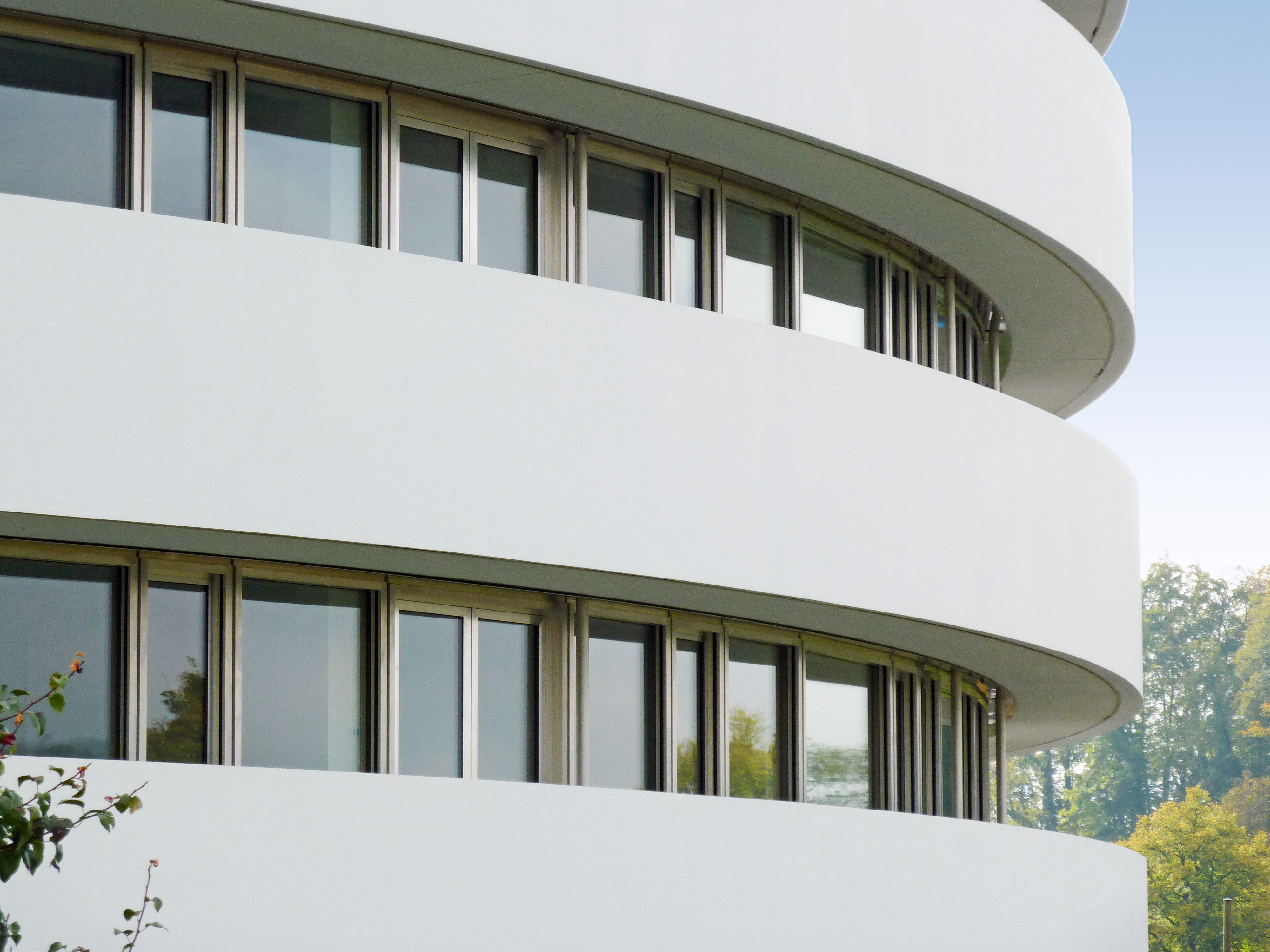 Obergeschossfassaden: Verschiedenste Elemente (Türen, Fenster und Festteile) reihen sich aneinander. Alle Bauteile sind in Aluminium roh ausgeführt.